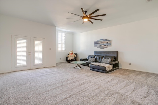 carpeted living room featuring ceiling fan, a wealth of natural light, and french doors