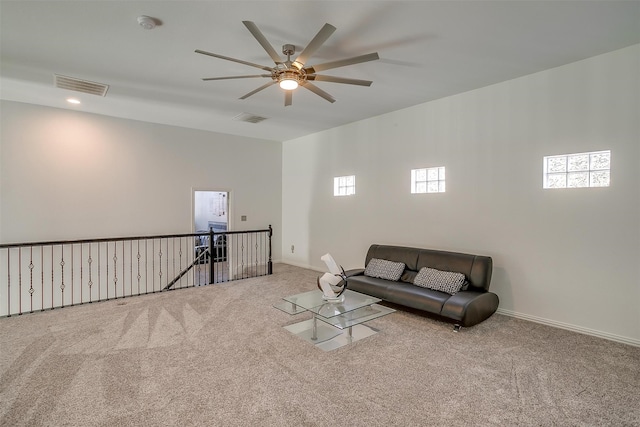 living room with plenty of natural light, ceiling fan, and light colored carpet