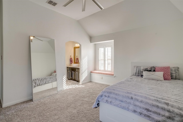 bedroom with ceiling fan, light colored carpet, high vaulted ceiling, and ensuite bath