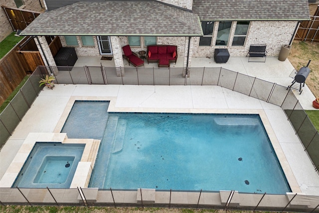 view of swimming pool featuring a patio area, a fenced backyard, and a pool with connected hot tub