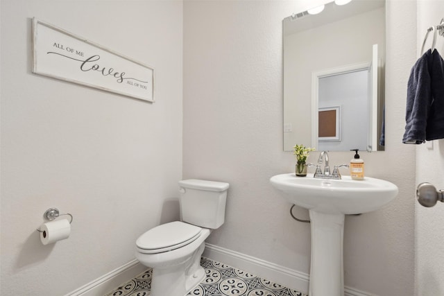 bathroom with visible vents, toilet, a sink, tile patterned flooring, and baseboards