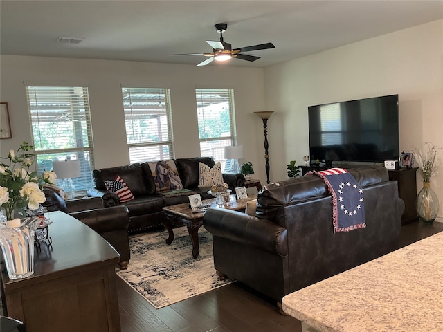 living room featuring ceiling fan and dark hardwood / wood-style floors