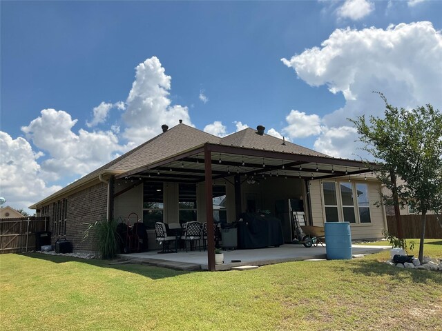 rear view of property featuring a lawn and a patio area