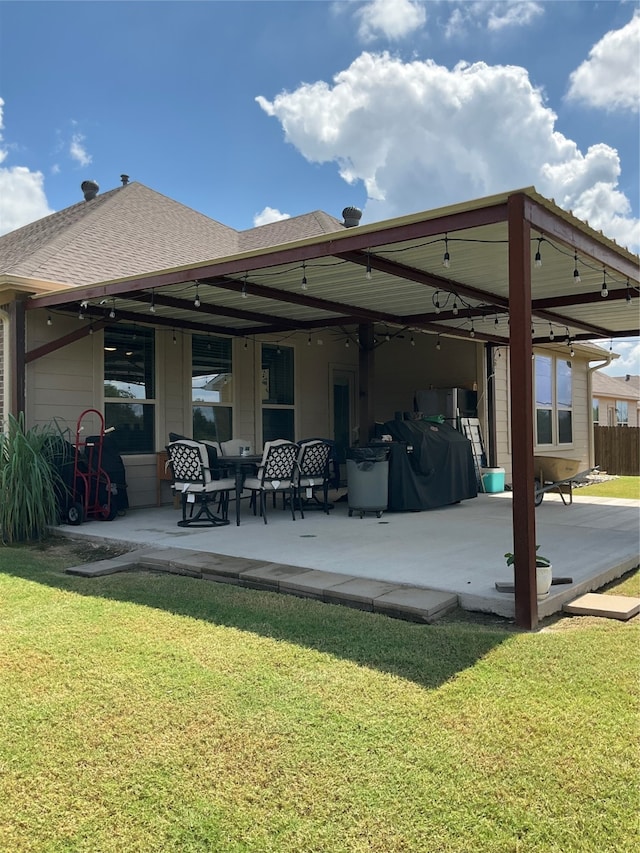 back of property with a yard and a patio area