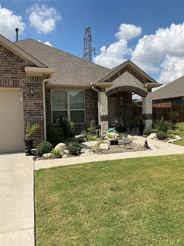 view of front of property with a front yard and a garage