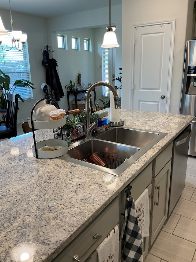 kitchen with plenty of natural light, an inviting chandelier, decorative light fixtures, and appliances with stainless steel finishes