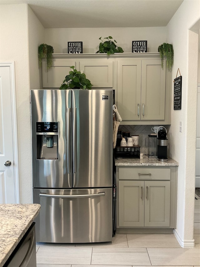 kitchen with tasteful backsplash, light stone countertops, and stainless steel appliances