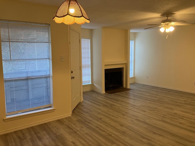 unfurnished living room featuring wood-type flooring, a textured ceiling, and ceiling fan