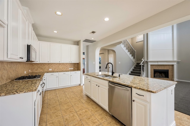 kitchen with white cabinets, sink, an island with sink, and stainless steel appliances