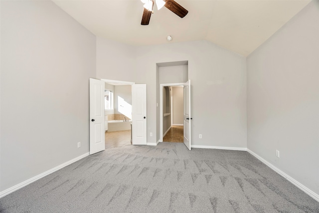 unfurnished bedroom with light carpet, connected bathroom, vaulted ceiling, and ceiling fan