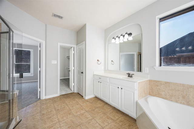 bathroom with tile patterned floors, plus walk in shower, and vanity