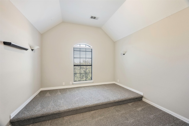 carpeted empty room featuring lofted ceiling