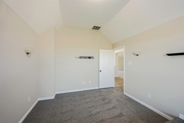 carpeted empty room featuring vaulted ceiling