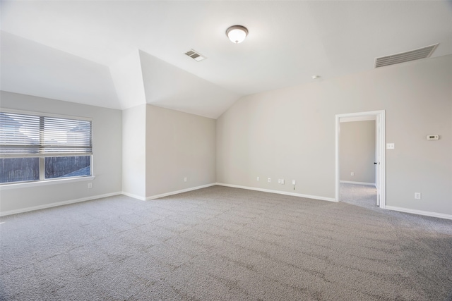 empty room featuring light carpet and lofted ceiling