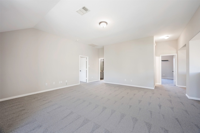 spare room with light carpet and vaulted ceiling