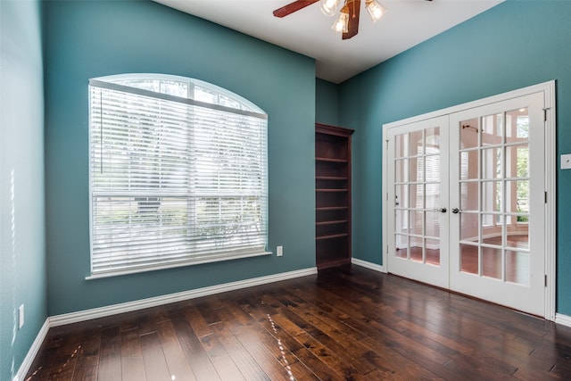 spare room with ceiling fan, french doors, and dark wood-type flooring