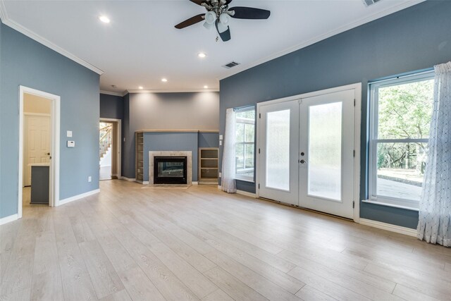 unfurnished living room with a wealth of natural light, light hardwood / wood-style flooring, and crown molding