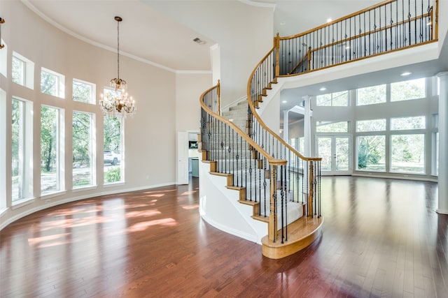 stairs with a high ceiling, hardwood / wood-style flooring, and a wealth of natural light