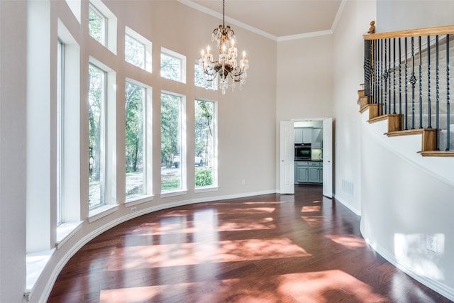 dining area with crown molding, dark wood-type flooring, a high ceiling, and a chandelier