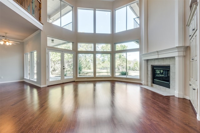 unfurnished living room featuring a high ceiling, dark hardwood / wood-style flooring, and plenty of natural light