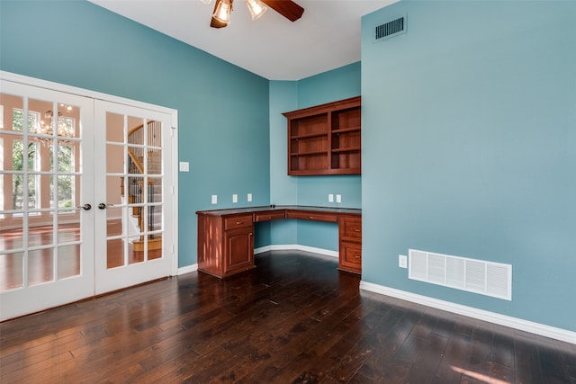 unfurnished office with french doors, built in desk, ceiling fan, and dark wood-type flooring