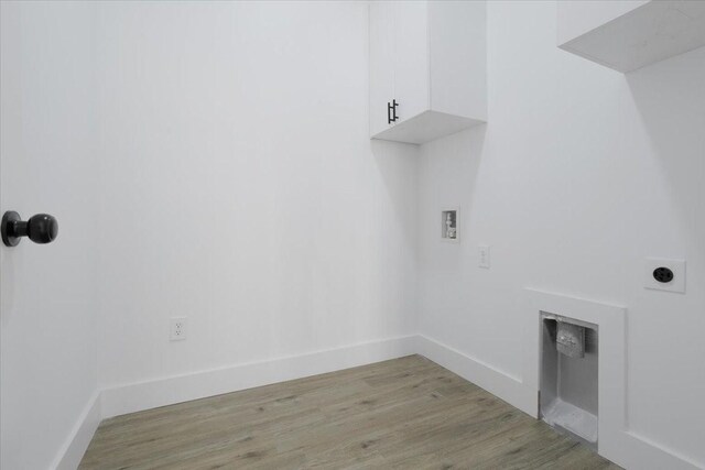 laundry area featuring cabinets, washer hookup, light hardwood / wood-style floors, and electric dryer hookup