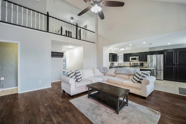 living room featuring hardwood / wood-style flooring, high vaulted ceiling, and ceiling fan