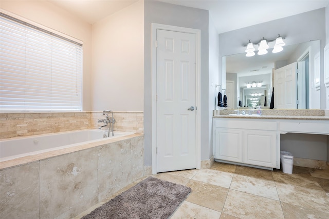 bathroom with vanity, tiled bath, and a wealth of natural light