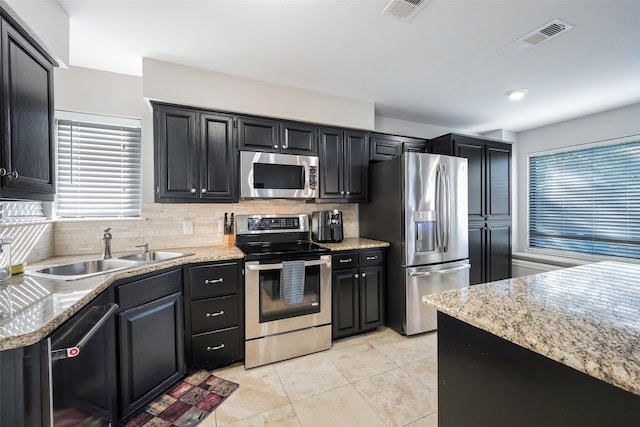 kitchen featuring a sink, stainless steel appliances, tasteful backsplash, and visible vents