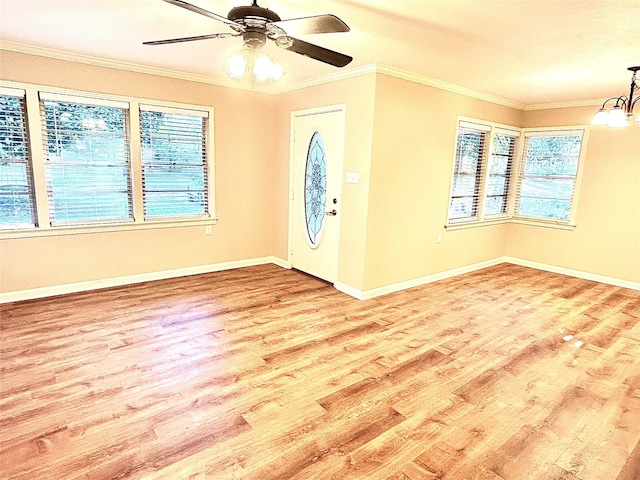 entrance foyer with light hardwood / wood-style floors, ceiling fan with notable chandelier, and ornamental molding