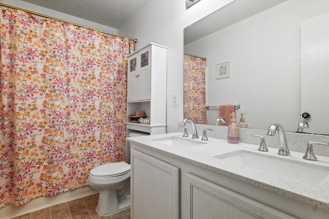 bathroom featuring vanity, toilet, and a textured ceiling