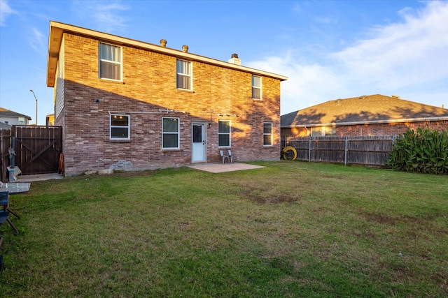 rear view of house with a patio area and a lawn