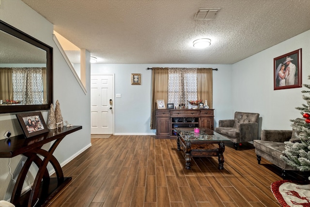 living room with dark hardwood / wood-style flooring and a textured ceiling