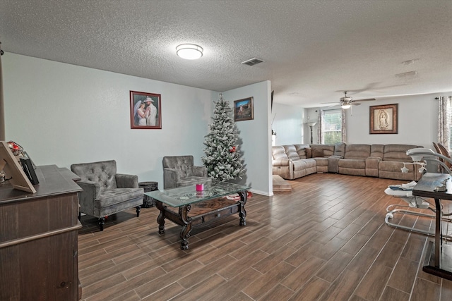 living room with ceiling fan and a textured ceiling