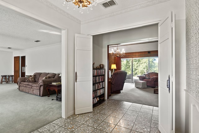 corridor featuring carpet flooring, a textured ceiling, and an inviting chandelier