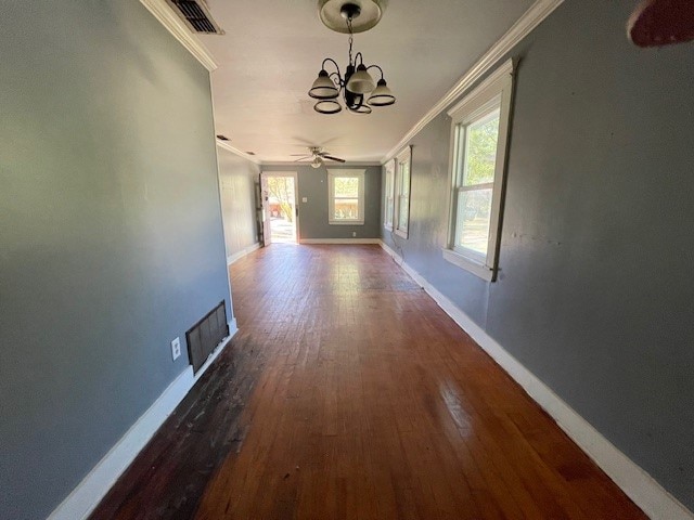 hallway with hardwood / wood-style flooring, an inviting chandelier, and crown molding