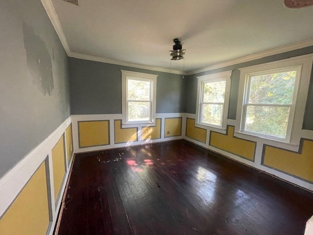 unfurnished room featuring a healthy amount of sunlight, dark hardwood / wood-style flooring, and crown molding