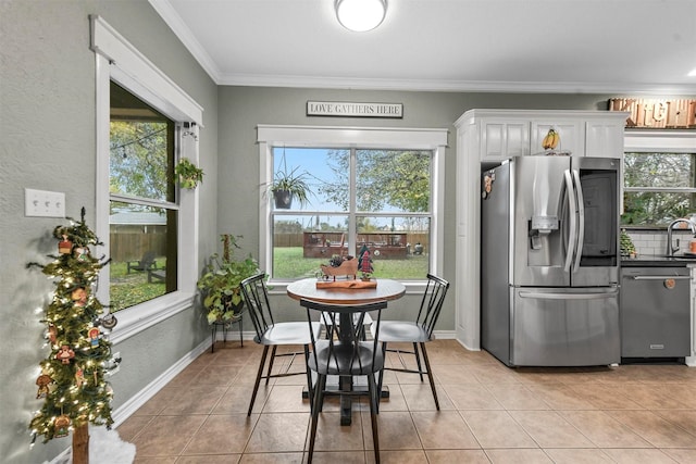 dining space featuring light tile patterned floors, ornamental molding, and sink