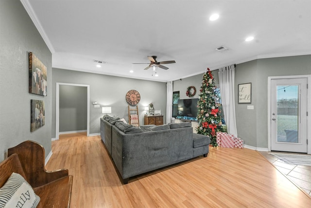 living room with light wood-type flooring, ceiling fan, and crown molding