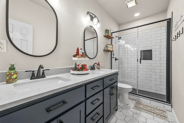 bathroom featuring a shower with door, vanity, and toilet