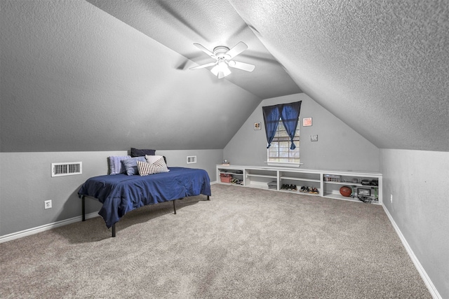 carpeted bedroom with a textured ceiling, vaulted ceiling, and ceiling fan