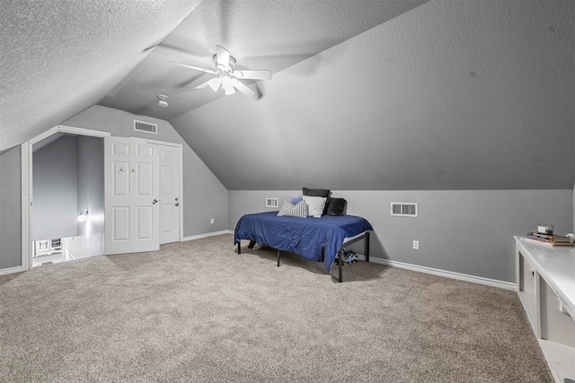 carpeted bedroom featuring a textured ceiling, ceiling fan, and lofted ceiling