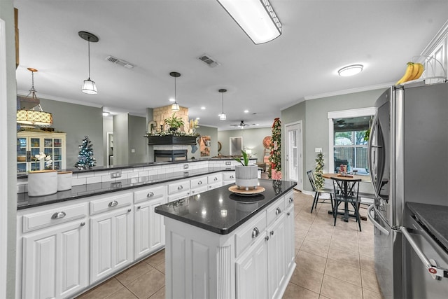 kitchen featuring stainless steel fridge, decorative light fixtures, white cabinetry, and ceiling fan