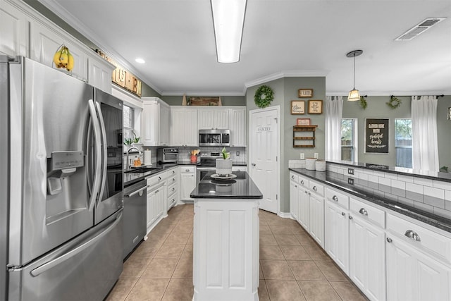 kitchen with a center island, white cabinets, light tile patterned floors, and appliances with stainless steel finishes