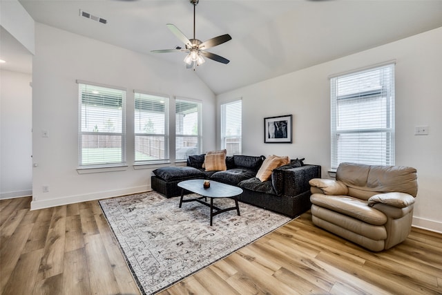 living room with ceiling fan, lofted ceiling, and light hardwood / wood-style flooring