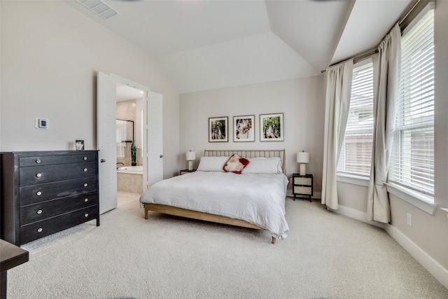 bedroom with ensuite bathroom, carpet floors, and lofted ceiling