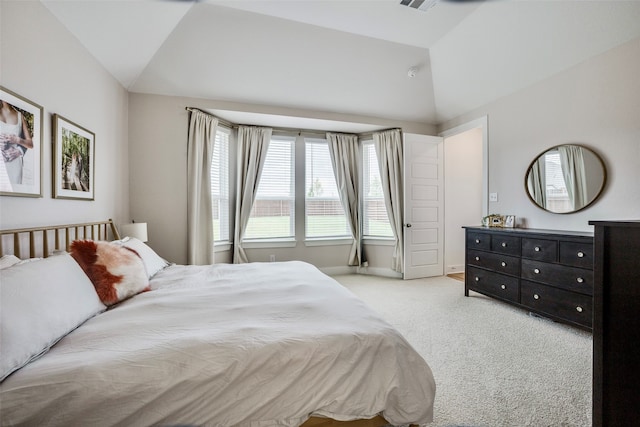 bedroom featuring light carpet and vaulted ceiling