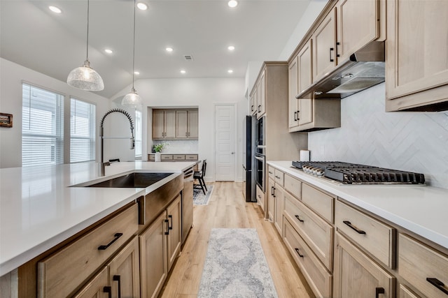 kitchen featuring pendant lighting, light hardwood / wood-style floors, tasteful backsplash, and light brown cabinetry