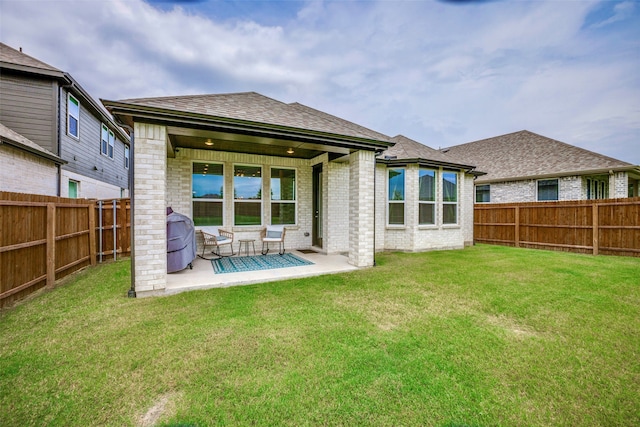 rear view of property with a yard and a patio