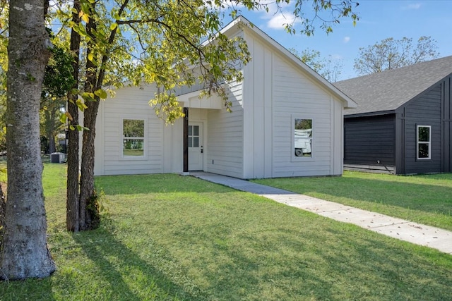 rear view of house with a lawn and central AC